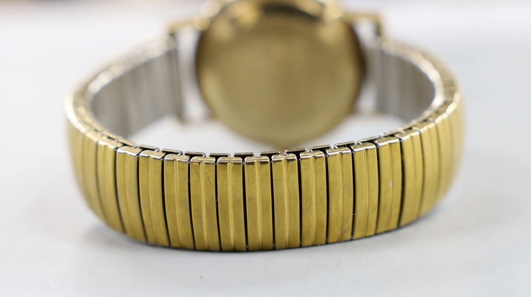 A gentleman's 1960' yellow metal Omega manual wind wrist watch, with date aperture, on associated flexible bracelet, no box or papers.